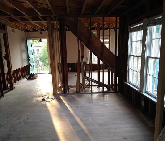 inside of home with sheetrock ripped out, only studs and some sheetrock left on some walls.